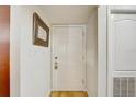 Bright entryway with hardwood floors, white door, and modern mirror at 2078 Sunset Point Rd # 83, Clearwater, FL 33765