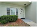 Street view of the front door with mulched garden bed and lush hedges underneath the front windows at 2256 Philippine Dr # 24, Clearwater, FL 33763