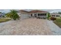 Beautiful home with a paver driveway, two car garage, and inviting front porch in a well-maintained community at 2457 E Del Webb Blvd, Sun City Center, FL 33573
