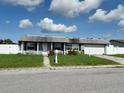Modest single-story home featuring a front yard, driveway, and attached garage at 2619 Albion St, Holiday, FL 34691