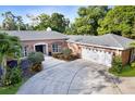 Beautiful brick home boasts an attached garage, large driveway, and professionally landscaped front yard at 302 Eastleigh Dr, Belleair, FL 33756
