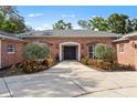 Charming brick home featuring a wide driveway, manicured landscaping, and a welcoming front entrance at 302 Eastleigh Dr, Belleair, FL 33756