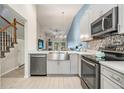 Modern kitchen featuring stainless steel appliances, a farmhouse sink, sleek countertops, and stylish cabinets at 3029 Brookfield Ln, Clearwater, FL 33761