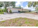 Spacious driveway leading to a two-car garage and features an American Flag at 35836 Lakeshore Dr, Dade City, FL 33525