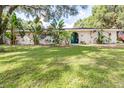 Charming single-story home featuring lush landscaping and an inviting front yard at 35836 Lakeshore Dr, Dade City, FL 33525