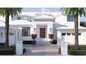 Elegant two-story white home featuring a brick facade, palm trees, a symmetrical design, and a well-maintained walkway at 38 Ladoga Ave, Tampa, FL 33606
