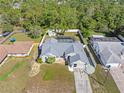 Aerial view of a charming property with a screened-in pool, fenced backyard, and mature trees at 4399 Dior Rd, Spring Hill, FL 34609