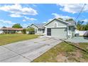 Single story home featuring an attached two-car garage with a long concrete driveway at 4399 Dior Rd, Spring Hill, FL 34609