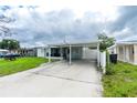 View of the single story home, including the carport and screened in patio at 4705 Murray Hill Dr, Tampa, FL 33615