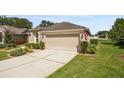 Well-maintained house with a two-car garage, concrete driveway, and a green lawn at 5131 Gato Del Sol Cir, Wesley Chapel, FL 33544