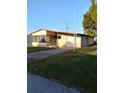 Inviting home with a covered garage, cozy front yard and driveway at 6443 Midland St, Zephyrhills, FL 33542