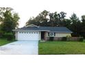 Charming single-story home with a well-maintained lawn, attached garage, and brick accents at 6605 Foxmoor Dr, Zephyrhills, FL 33542