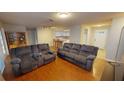 Spacious living room with hardwood floors, comfortable seating, and access to kitchen at 6605 Foxmoor Dr, Zephyrhills, FL 33542