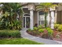 Close-up of front door with decorative glass and landscaped walkway at 803 Brooker Village Cir, Lutz, FL 33548