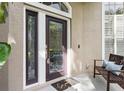 Covered front porch featuring decorative glass door and side lights, bench, and textured wall at 803 Brooker Village Cir, Lutz, FL 33548