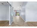 Bright foyer featuring tile flooring and a decorative barn door leading to an adjacent room at 8836 Alafia Cove Dr, Riverview, FL 33569