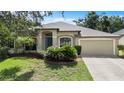 Inviting single-story home featuring a well-maintained lawn, mature landscaping, and a two-car garage at 8836 Alafia Cove Dr, Riverview, FL 33569