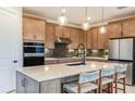 Modern kitchen featuring sleek cabinets, stainless steel appliances, and a spacious island with seating at 10305 Cross River Trl, Parrish, FL 34219