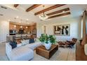 Inviting living room showcasing exposed beams, an open floor plan, and seamless kitchen integration at 10305 Cross River Trl, Parrish, FL 34219
