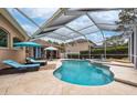 A serene screened-in pool area with seating and a view at 10532 Plantation Bay Dr, Tampa, FL 33647