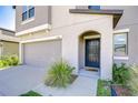 A gray stucco house showcasing an arched entry and gray garage door at 15505 Wicked Strong St, Sun City Center, FL 33573