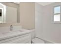 Bright bathroom featuring a white vanity with granite counters, a mirror, and a shower over a tub with a window at 1621 Crossridge Dr, Brandon, FL 33510