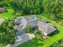 Aerial view of a single-Gathering home with a screened-in pool, spacious backyard, and mature trees surrounding the property at 17311 Carriage Way, Odessa, FL 33556