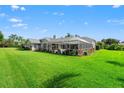 Expansive backyard with a screened-in pool area, lush landscaping, and plenty of space for outdoor activities at 17311 Carriage Way, Odessa, FL 33556