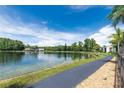 Scenic view of the lake with a walking path and lush greenery on a sunny day at 3114 Lake Pine Way # H2, Tarpon Springs, FL 34688