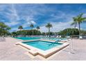 Resort-style pool area with sparkling blue water, lounge chairs, palm trees, and sunny sky at 3114 Lake Pine Way # H2, Tarpon Springs, FL 34688
