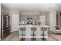 Modern eat-in kitchen featuring stainless appliances, gray cabinets and a center island with seating at 36964 Sagemoor Dr, Zephyrhills, FL 33541
