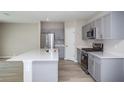 Modern kitchen features gray cabinets, stainless steel appliances, and a spacious white countertop island at 36964 Sagemoor Dr, Zephyrhills, FL 33541
