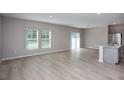 Staged open-concept living and kitchen area with modern furniture and wood-look floors at 36964 Sagemoor Dr, Zephyrhills, FL 33541