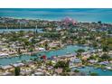 Gorgeous aerial view of neighborhood canals with turquoise ocean and pink hotel in the background at 417 41St Ave, St Pete Beach, FL 33706