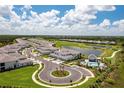 Beautiful aerial view of a community, with a pool, golf course, and manicured landscaping, under a partly cloudy sky at 43250 Water Bird Way # 5921, Punta Gorda, FL 33982