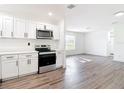 Bright, open kitchen with stainless steel appliances, white cabinets, and wood-look floors at 485 Stillwater Ave, Spring Hill, FL 34606
