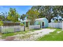 Rear view of turquoise home with white picket fence, offering outdoor charm at 5119 23Rd S Ave, Gulfport, FL 33707