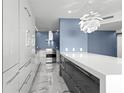 Modern kitchen featuring sleek cabinets, stainless steel appliances, tile flooring, and unique pendant lighting at 5153 Isla Key S Blvd # 415, St Petersburg, FL 33715