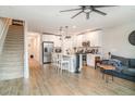 Open-concept living room showcasing the kitchen, hardwood floors, and modern decor elements, with a staircase on the left at 5519 Tripoli Dr, Palmetto, FL 34221