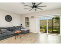 Bright living room featuring a comfortable gray couch, ceiling fan, tile floors, and a sliding door to the outside at 5519 Tripoli Dr, Palmetto, FL 34221