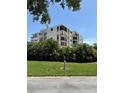 Exterior view of condo building surrounded by manicured landscaping and clear blue skies at 6218 Palma Del Mar # 303, St Petersburg, FL 33715
