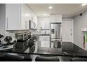 Modern kitchen with black countertops, stainless appliances, and white cabinetry at 801 83Rd N Ave # 412, St Petersburg, FL 33702
