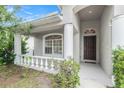 Inviting front porch with decorative columns, leading to the home's front door and windowed facade at 8104 Abbey Mist Cv, Tampa, FL 33619