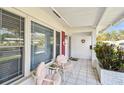 Inviting front porch features tiled flooring, comfortable seating and ample natural light at 9548 141St St, Seminole, FL 33776