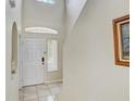 Bright entryway boasting tiled floors, soaring ceilings, and a classic six-panel front door at 10437 River Bream Dr, Riverview, FL 33569