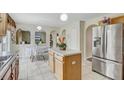 Charming kitchen with island, stainless steel refrigerator, and arches leading to the dining area at 10437 River Bream Dr, Riverview, FL 33569