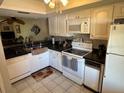 Well-lit kitchen with white cabinets, modern appliances, and tiled floor at 110 Lakeside Ct # 110, Oldsmar, FL 34677