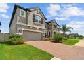 Beautiful home exterior featuring a brick driveway and a lush, green lawn at 11002 Sundrift Dr, Tampa, FL 33647