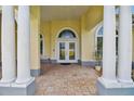 Elegant entryway featuring grand columns, a patterned brick floor, and double glass doors at 1109 Colson Rd, Plant City, FL 33567
