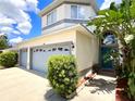 Inviting home featuring a two-car garage and covered entryway with a pop of tropical landscaping at 11122 Kempton Vista Dr, Riverview, FL 33579
